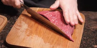 厨师在木板上切肉。餐厅里的新鲜生肉。有选择性的重点。