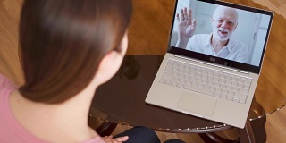 在国外留学的女儿在笔记本电脑上通过即时通讯软件和她的父亲视频聊天