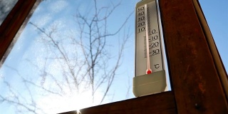 温度计在太阳的背景下。美丽的阳光。零度以上的温度