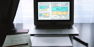 Web开发人员坐在桌子前绘制未来网站的草图。在家办公远程办公