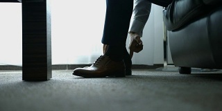 这个男人穿鞋。把鞋带系在鞋子上。男人的风格。去准备工作，去开会。