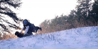 小男孩跑进爸爸的手里，在森林的背光慢镜头里，他们落在雪地上