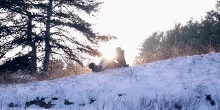 一家人一起在森林里玩，小男孩跑到了爸爸的手里，他们在慢镜头里落在了雪地上
