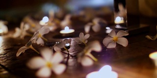 近看，美丽的夜晚装饰在地板上，摆放蜡烛，摆放鲜花，白玉兰，浪漫的氛围，夜晚，蜜月
