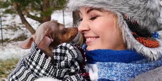 冬天，一个女人和她的小狗在外面玩耍