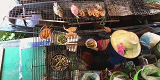 虾、海鲜在曼谷水上市场与船上的人烹饪在煤炭上烹饪- Taling Chan水上市场与当地船只。泰国菜。