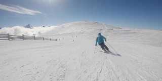 在阳光明媚的冬日，高山滑雪者在滑雪场滑雪