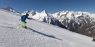 在阳光明媚的冬日，高山滑雪者在滑雪场滑雪