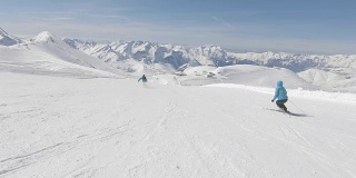 两个高山滑雪者在山坡上快速滑行
