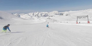 两个高山滑雪者在山坡上快速滑行
