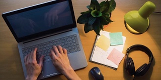 一个人晚上在办公室用笔记本电脑工作，双手俯视图，延时拍摄