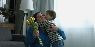 小男孩在家用鲜花使母亲感到惊奇