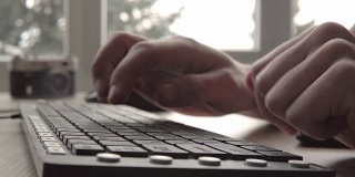 近距离敲击键盘。在电脑键盘上打字的人。人的手用电脑键盘和鼠标打字。自由摄影师与电脑工作。