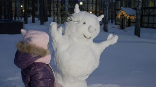 小女孩在雪地里堆雪人，看着它视频素材模板下载