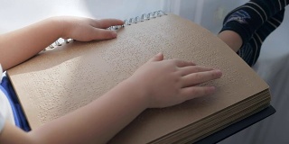 视障儿童正在用手阅读盲文