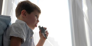 喷雾器操作过程中，患病儿童通过吸入器管呼吸用于治疗呼吸道疾病