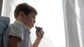 喷雾器操作过程中，患病儿童通过吸入器管呼吸用于治疗呼吸道疾病视频素材模板下载