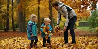 童年时光:少年儿童在公园里与秋叶嬉戏