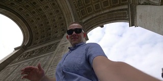 一名男子在用4k慢镜头拍摄巴黎凯旋门的自拍照