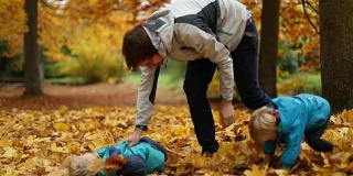 童年时光:少年和孩子们在2号公园玩秋叶