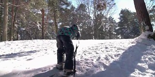 可爱的小男孩在下雪的冬天拉着雪橇爬山