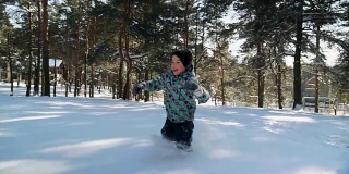 冬天，一个小男孩在白雪覆盖的森林里奔跑
