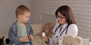 医生给医院里的小孩吃药。