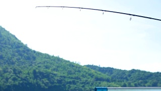 渔夫在河上用钓竿钩住上钩的鱼视频素材模板下载