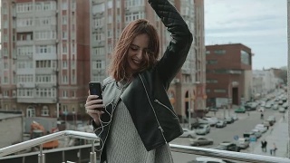 摇滚风格的女人在城市里听着音乐跳舞视频素材模板下载