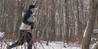 一个人在冬天的森林里晨跑。运动员奔跑的人