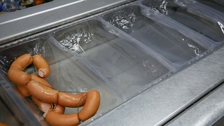 肉类产业。食品包装机-新鲜香肠在一个托盘视频素材模板下载