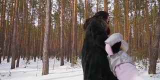 快乐的一家人一起在冬天的森林里玩，慢镜头