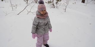 可爱的小女孩摔倒在雪地上，慢镜头