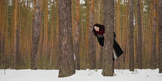 在冬天的森林里，一个漂亮的女人和一个小女孩从树上向外凝视