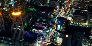 从空中的角度看，曼谷市中心夜间灯光照亮的街道和多种颜色的交通