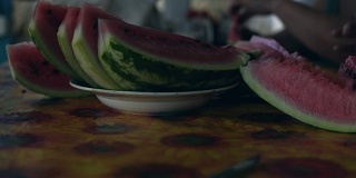 特写镜头:切成片熟透的西瓜放在盘子里的桌子上