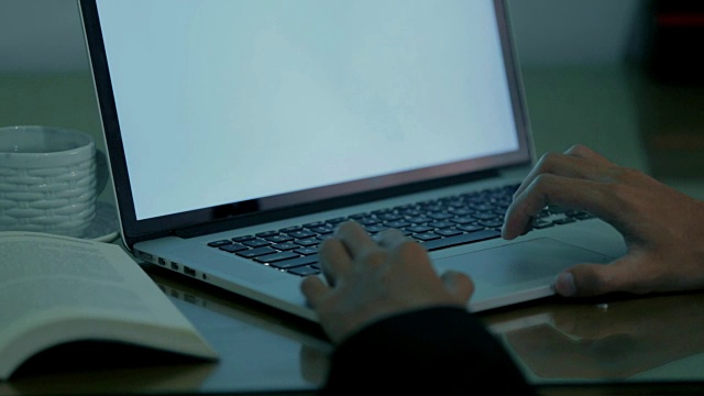 特写的年轻商人使用笔记本电脑/电脑的工作与白色屏幕在办公室有两种色调