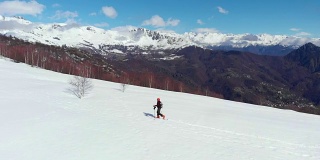 徒步者攀登雪山，滑雪旅游偏僻的雪道独自登山，风景秀丽的雪山背景。