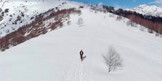 徒步者攀登雪山，滑雪旅游偏僻的雪道独自登山，风景秀丽的雪山背景。