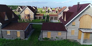 未完工的村舍，废弃的村舍，一个村舍小镇，几栋房屋，绿色的草坪，从上面俯瞰，鸟瞰