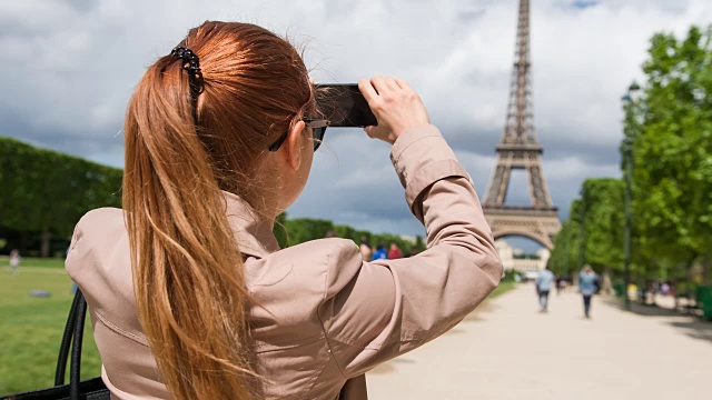 在战神广场的女人正在拍摄埃菲尔铁塔