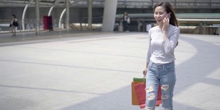 年轻的亚洲女人在手机上购物。