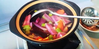 在厨房用砂锅炖萝卜
