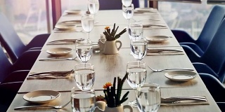 宴席装饰餐桌，用刀叉。近距离的优雅，装饰桌子准备一个豪华的晚餐在日落时间的窗户。缓慢的运动。1920 x1080