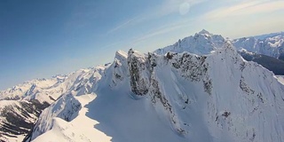 史诗航空镜头飞行近雪覆盖的锯齿山山脊后面的舒克山喀斯喀特山华盛顿州Whatcom县的尖峰