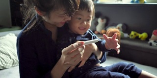 一位亚洲母亲和她的儿子发现了验孕棒