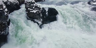 狂暴的冰寒冷的岩石河在冬天的雪急流