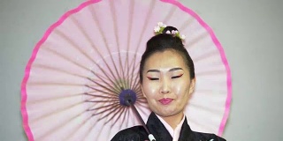 美丽的艺妓穿着传统的日本和服和阳伞