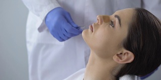 外科医生从鼻子取出石膏，妇女满意的鼻整形结果