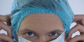 男医师戴着外科口罩，准备对病人进行检查，特写